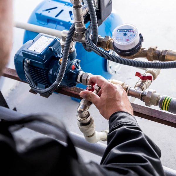 Technician checking water system nodes. Industrial background